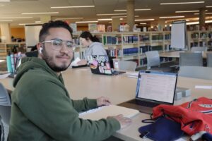Student working at the library on a laptop