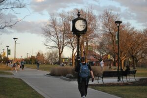 Students passing the clock tower at dusk